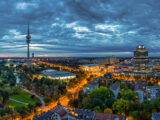 Die BMW Welt und der Münchner Olympiaturm am Abend beleuchtet