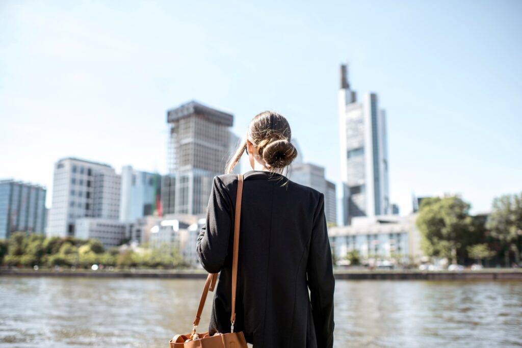 Eine Geschäftsfrau blickt auf die Skyline von Frankfurt am Main, symbolisierend die Karrieremöglichkeiten und die Rolle von Headhuntern in der Stadt