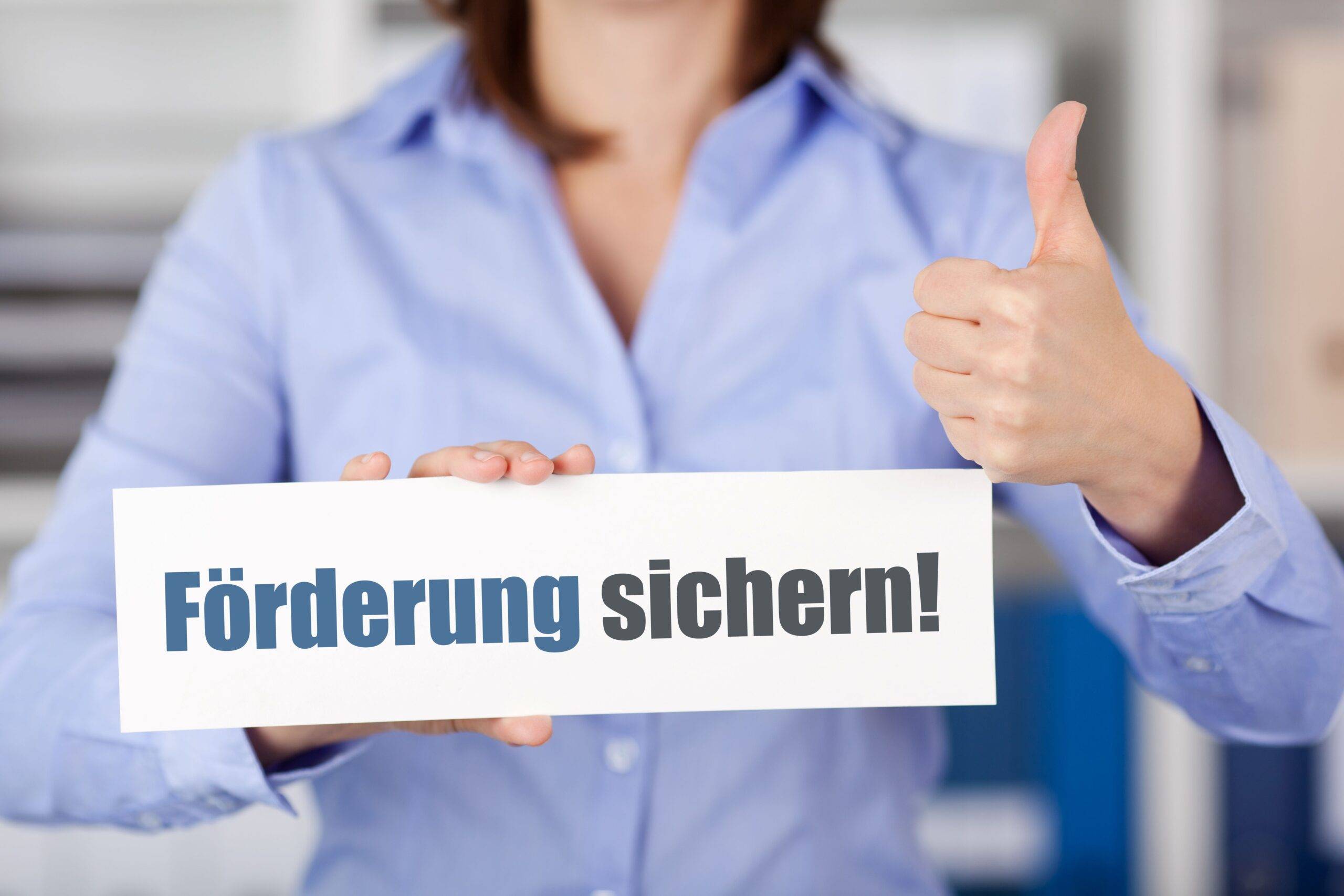 Frau hält ein Schild mit der Aufschrift "Förderung sichern"