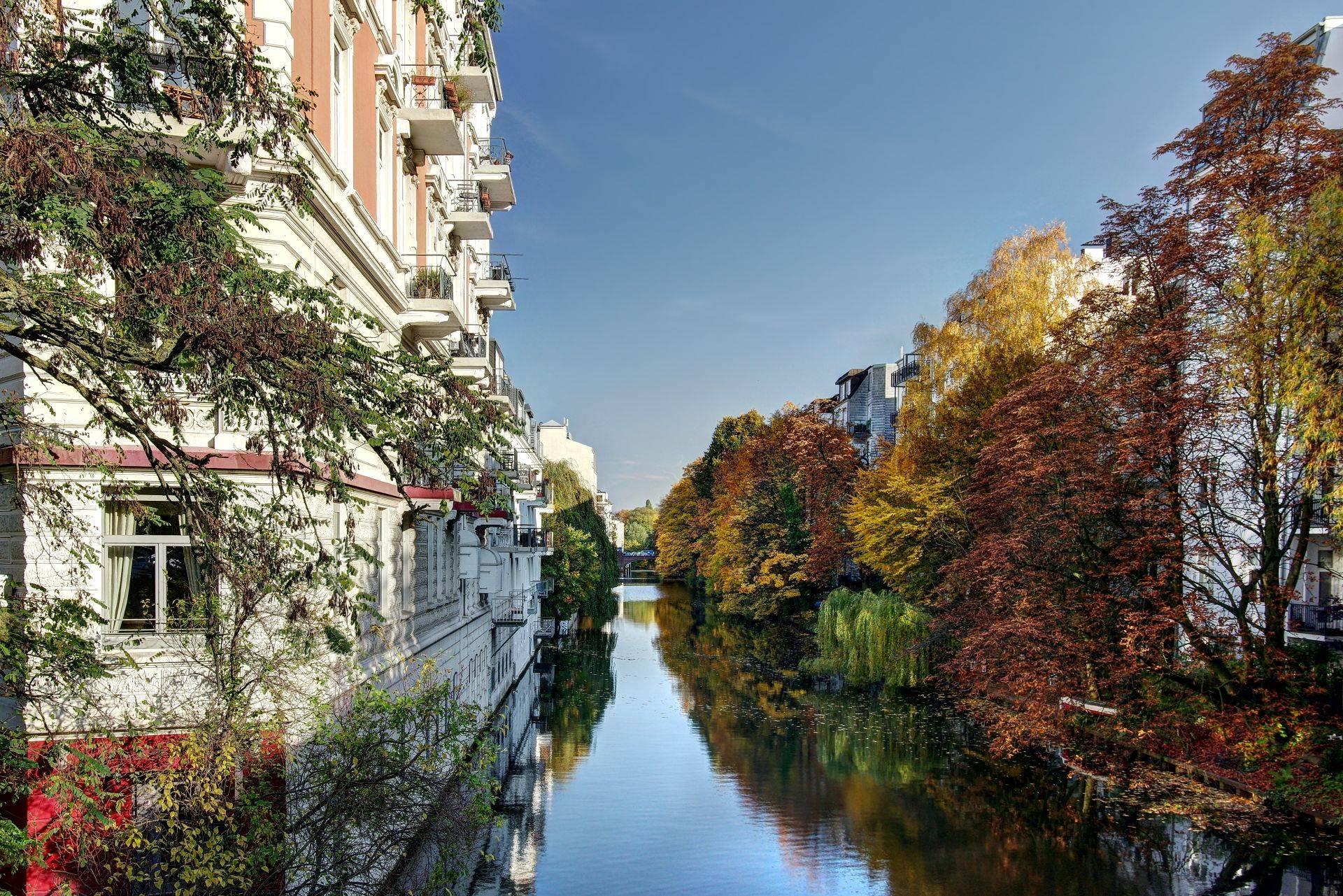 Altbauten am ruhigen Kanal in Hamburg mit herbstlich gefaerbten Baeumen