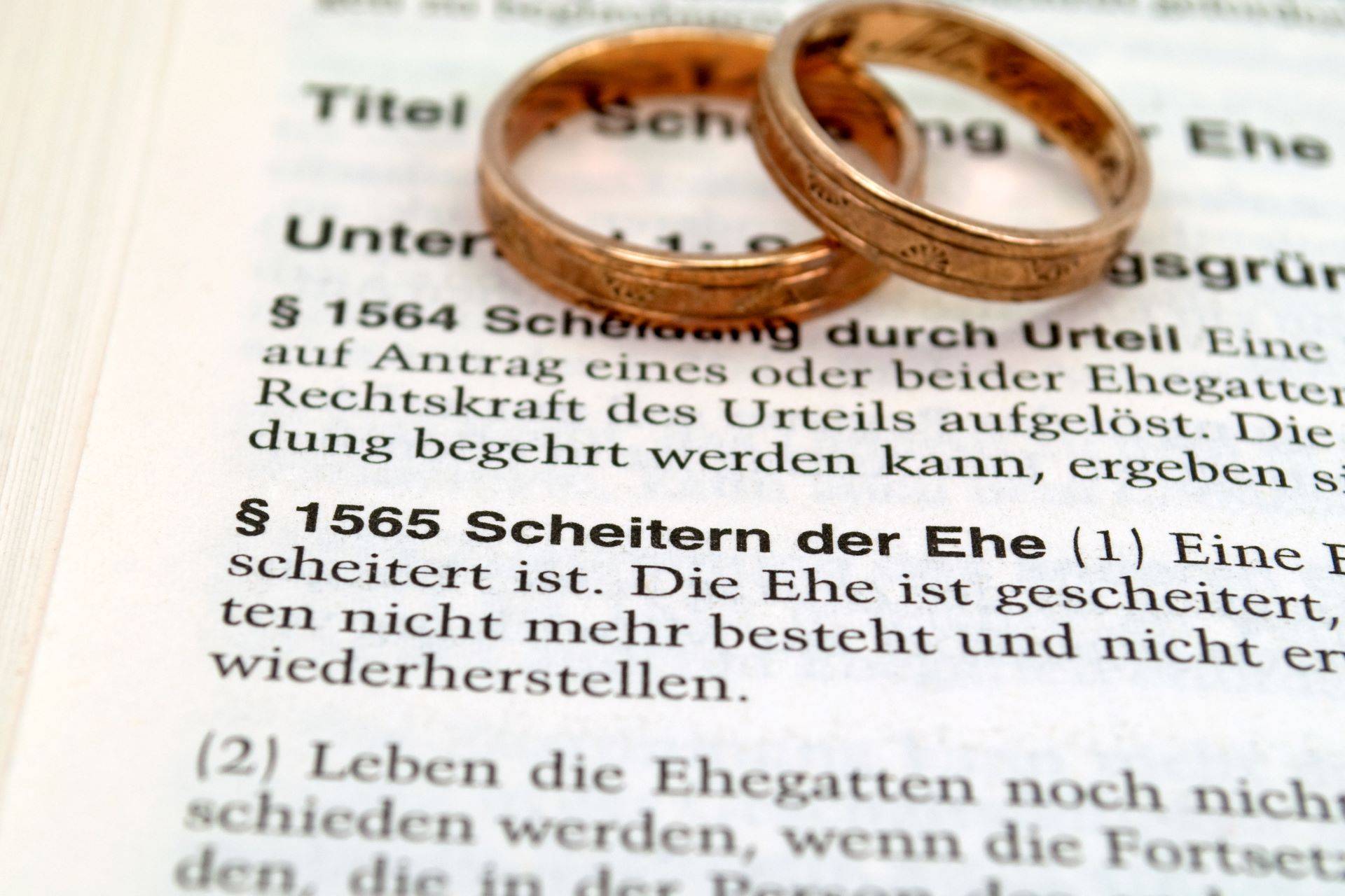 Zwei Eheringe auf Paragraf zum Scheidungsrecht