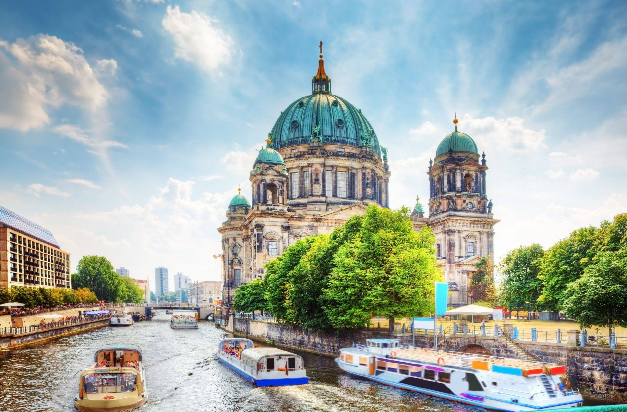 Berliner Dom an der Spree mit Ausflugsbooten bei Sonnenschein