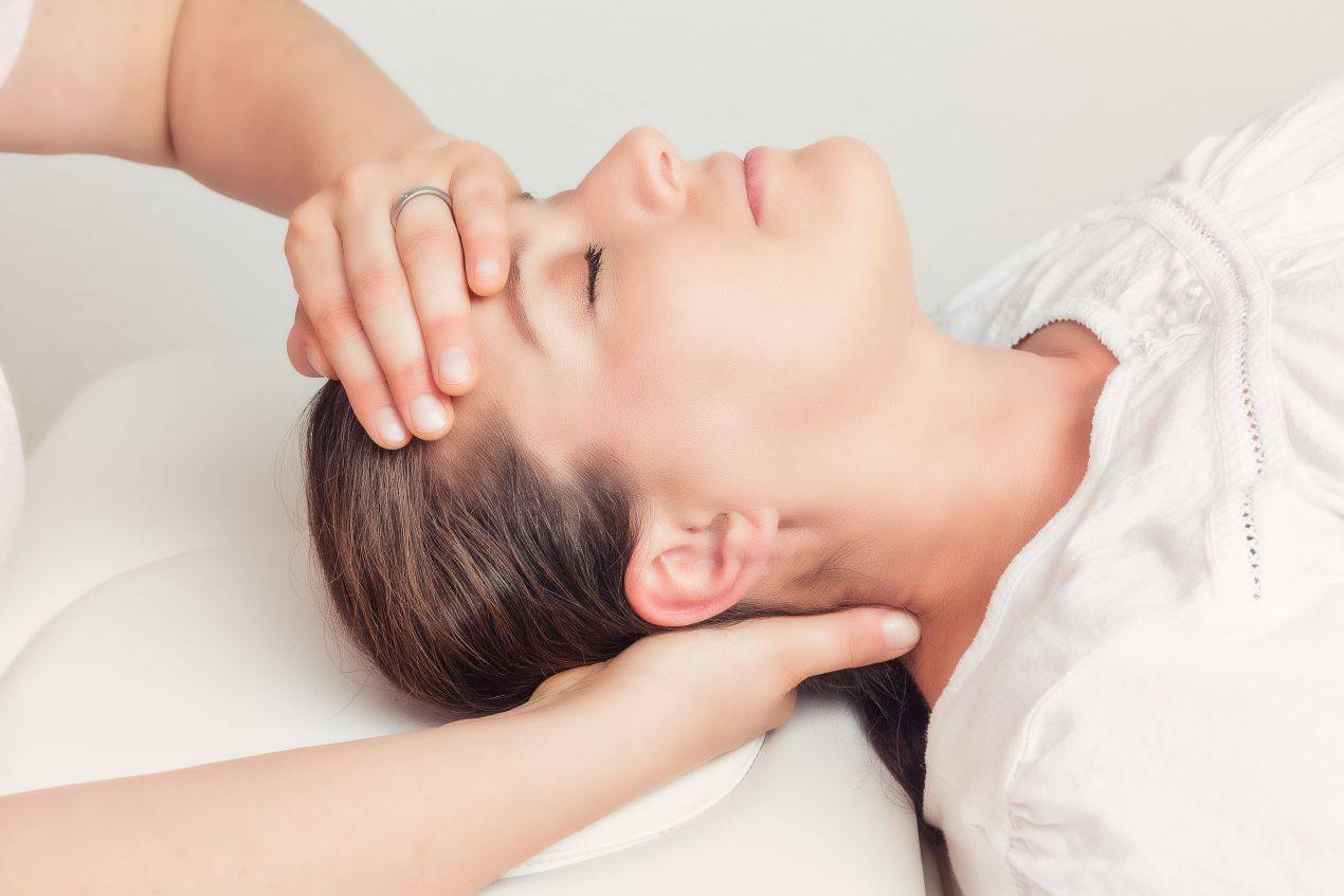 Nahaufnahme einer Frau in entspannter Lage während einer sanften osteopathischen Kopfbehandlung – angewendet in Osteopathie Freiburg Praxen