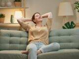Entspannte Frau auf Sofa im ordentlichen Zuhause